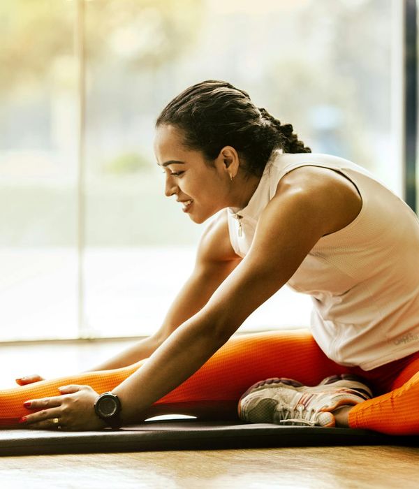 Smiling woman stretching gently outdoors, feeling full of energy and vitality.